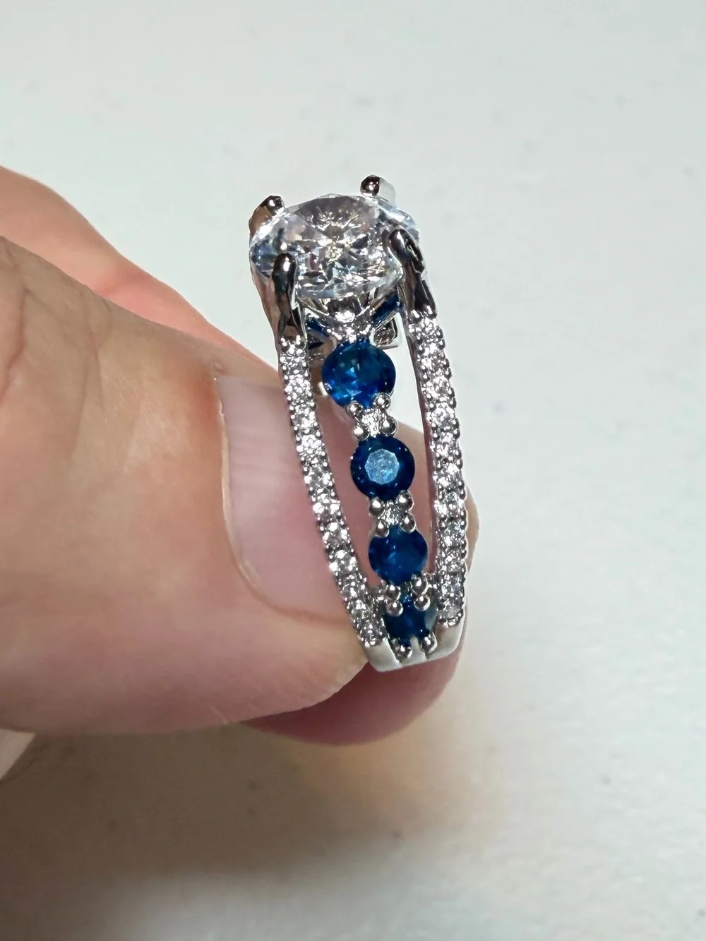 Silver Ring with Deep Blue Stones and Clear Center Gem.